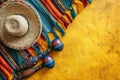 Mexican sombrerocas and poncho on yellow background