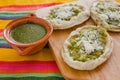 Mexican sopes with grated cheese and green salsa, mexican food spicy in mexico