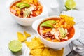 Mexican soup Chili con carne with beans, chicken, corn and nachos in white bowls - traditional mexican food