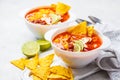 Mexican soup Chili con carne with beans, chicken, corn and nachos in white bowls - traditional mexican food