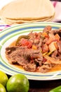 Mexican stake dish with tortillas and lime