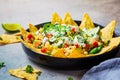 Mexican street corn salad with cheese and nachos chips in black plate. Mexican food concept Royalty Free Stock Photo