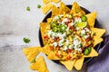 Mexican street corn salad with cheese and nachos chips in black plate, top view. Mexican food concept Royalty Free Stock Photo