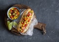 Mexican street style hot dog with corn salsa on a wooden cutting board on dark background Royalty Free Stock Photo