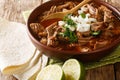 Mexican style slow cooked beef stew Birria de Res served with lime and tortilla closeup in a bowl. horizontal