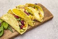 Mexican taco with chicken meat, red beans, fresh vegetables on wooden board. Latin american food, stone background