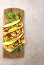 Mexican taco with chicken meat, red beans, fresh vegetables on wooden board. Latin american food, stone background