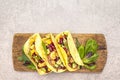 Mexican taco with chicken meat, red beans, fresh vegetables on wooden board. Latin american food, stone background