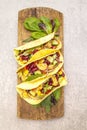 Mexican taco with chicken meat, red beans, fresh vegetables on wooden board. Latin american food, stone background, top view,