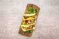 Mexican taco with chicken meat, red beans, fresh vegetables on wooden board. Latin american food, stone background, top view copy