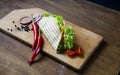 Mexican tacos with chicken meat, salad and vegetables sauce presented on a wooden board with a chilly pepper tomato and Royalty Free Stock Photo