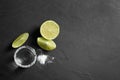 Mexican Tequila shot, lime slices and salt on black table. Space for text Royalty Free Stock Photo