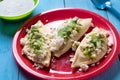 Mexican tlacoyos with green sauce on blue background