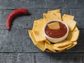 The Mexican tortilla chips with cheese and chili peppers on a rustic table. Royalty Free Stock Photo