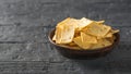 Mexican tortilla chips with cheese in a clay bowl on a rustic wooden table. Copy space. Royalty Free Stock Photo