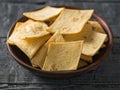 Mexican tortilla chips with cheese in a clay bowl on a rustic wooden table. Royalty Free Stock Photo