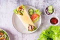 Mexican tortilla wraps with  vegetables and chicken on a plate on the table. Top view Royalty Free Stock Photo