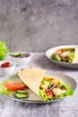 Mexican tortilla wraps with  vegetables and chicken on a plate on the table. Vertical view Royalty Free Stock Photo
