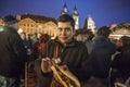 Mexican tourist enjoying hot chicken meat skewer from Christmas kiosk during Christmas event of lighting a Christmas tree at the O