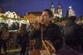 Mexican tourist enjoying hot chicken meat skewer from Christmas kiosk during Christmas event of lighting a Christmas tree at the O