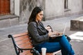 Mexican woman working with her laptop in a park bench in a colonial city in Latin America Royalty Free Stock Photo