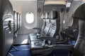 Inside of an empty commercial plane with grey leather seats close to emergency exit Royalty Free Stock Photo