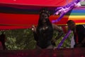 Beautiful woman wearing a lace dress stockings and a mask on a float at the march for LGBTTI Pride