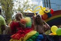 Wearing rainbow colors and ball gown makeup surrounded by coloured balloons manifest LGBTTTI pride traveling in allegorical car