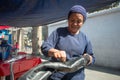 Maria Cristina, Old Shoe Shiner Woman from Guatemal is Sewing to Repare a Leather Coat