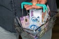 Mexico money, Man holding a shopping cart full of money, Financial concept, Shopping and expenses for daily life, Mexican pesos