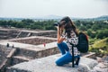 MEXICO - SEPTEMBER 21: Girl kneeling to take a picture of the landscape from the Pyramid of the moon