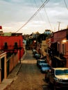 Mexico streetscape of historic buildings in san miguel allende and cars and village on horizon