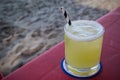 Mezcal Margarita made with fresh lime juice served in a glass with a paper straw on the beach Royalty Free Stock Photo