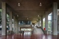 mezzanine, large empty room, brutalist architecture, with ceiling lamps, stairs and a red tile floor.