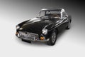 MG MGB black roadster soft top convertible car over a gradient background. Royalty Free Stock Photo