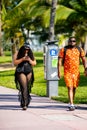 Fashionable young African American couple walking in Miami Beach shot with telephoto lens