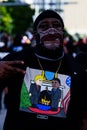 Miami Downtown, FL, USA - MAY 31, 2020: The black man in the mask. T-shirt with an illustration about Donald Trump and a