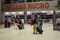 People walking with suitcases and Besame Mucho flower sign at Miami International Airport . Royalty Free Stock Photo