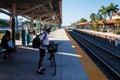 Passenger in helmet with bicycle waits for Tri rail train on Hollywood station platform
