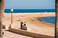 MIAMI PLATJA, SPAIN - APRIL 24, 2017: A man is taking pictures of a woman on the embankment. Copy space. Royalty Free Stock Photo