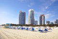 Miami South Beach with beach chairs and umbrellas , blue sky , and view of skyline condos and hotels Royalty Free Stock Photo