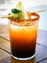 Michelada beer with tomato juice. Clamato with beer on wooden table. Royalty Free Stock Photo