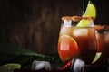 Michelada - Mexican alcoholic cocktail with beer, lime juice, tomato juice, spicy sauce and spices, vintage wooden background,