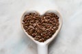 Brown Flaxseeds in a Heart Shape Spoon