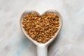 Gold Flaxseeds in a Heart Shape Spoon