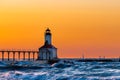 Michigan City, Indiana / USA : 03/23/2018 / Washington Park Lighthouse bathed in a beautiful sunset with Chicago looking over her Royalty Free Stock Photo