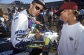 Mickey Thompson, promoter of off-road racing and vehicles, autographs a photo for a fan at the Rose Bowl in Pasadena, California.