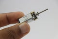 Micro dc gear motor or called as mini gear dc motor with long shaft held in the hand on white background