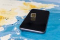 Micro SIM card and smartphone on the world map Royalty Free Stock Photo
