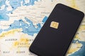 Micro SIM card and smartphone on the world map Royalty Free Stock Photo